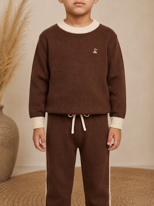 Child wearing a brown sweater and matching pants with the Small Land flag embroidery logo, standing against a neutral background.