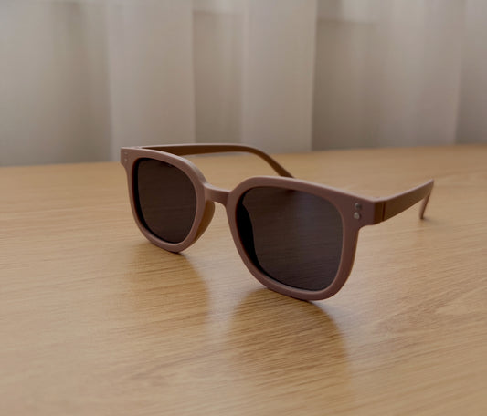 Sunglasses with brown frames and dark lenses on a wooden surface