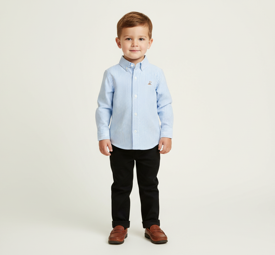 Young boy wearing a light blue pinstripe shirt and black pants on a white background