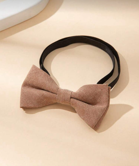 Brown bow tie on a beige surface