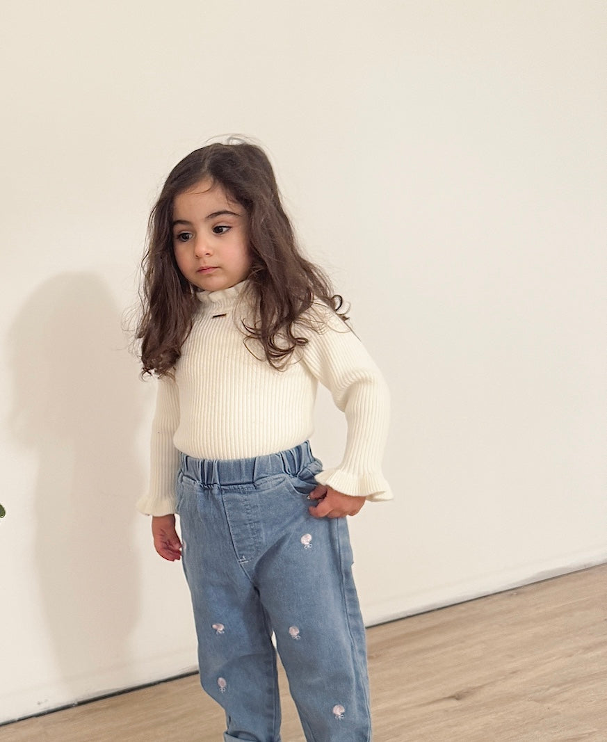 Toddler girl wearing the Gigi long sleeve winter knit in white, paired with our  toddler girl high waist denim Jean