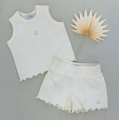 flat lay of ribbed top and short on plain grey background 