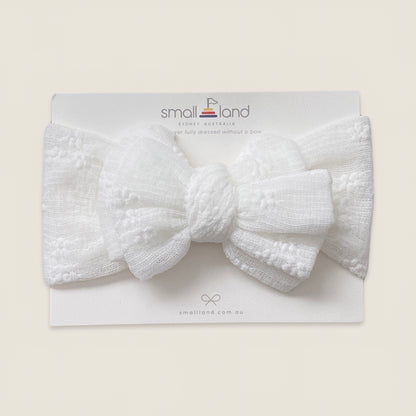 Flat lay image of girls white lace headband in Small Land packaging 