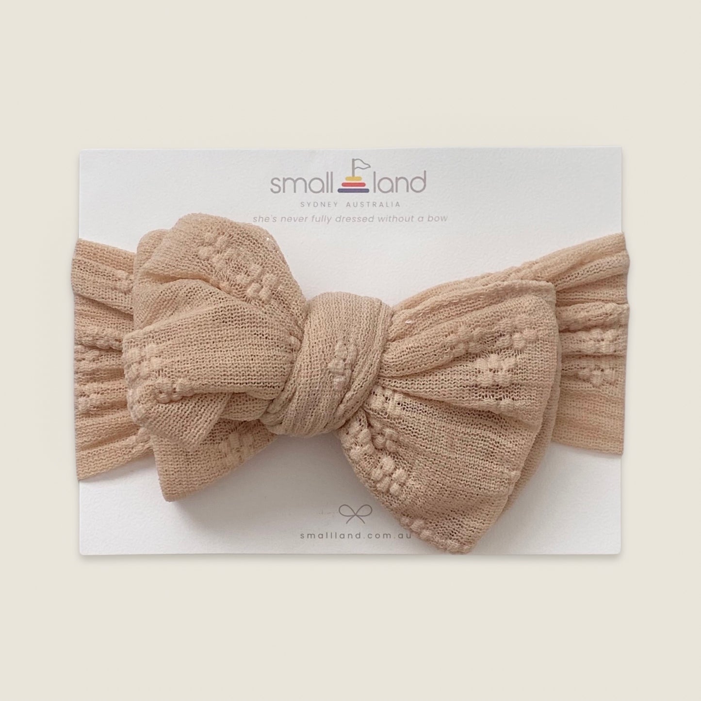 Flat lay image of girls beige lace headband in Small Land packaging 