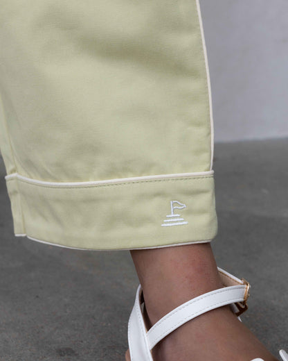 Close up detail of hem of pant, showing piping detail in white, and logo embroidery