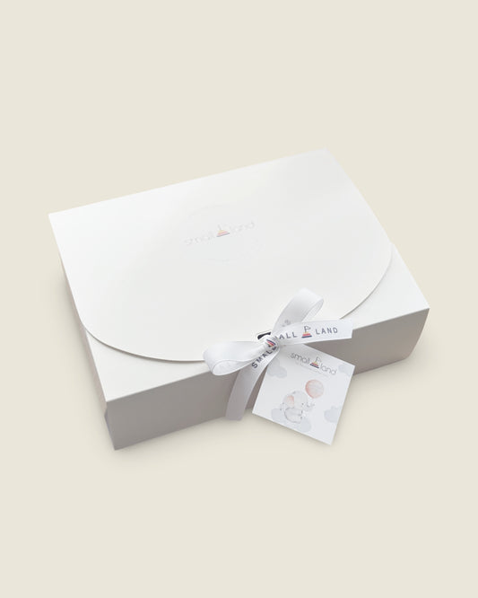 White envelope with a white ribbon and card on a beige background
