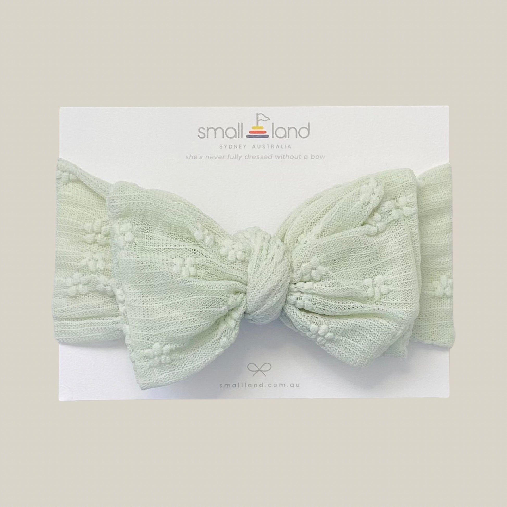 Flat lay image of girls sage lace headband in Small Land packaging 