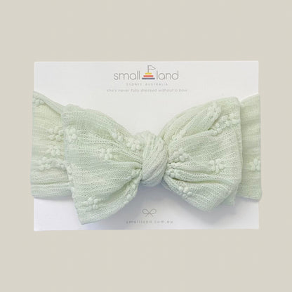 Flat lay image of girls sage lace headband in Small Land packaging 