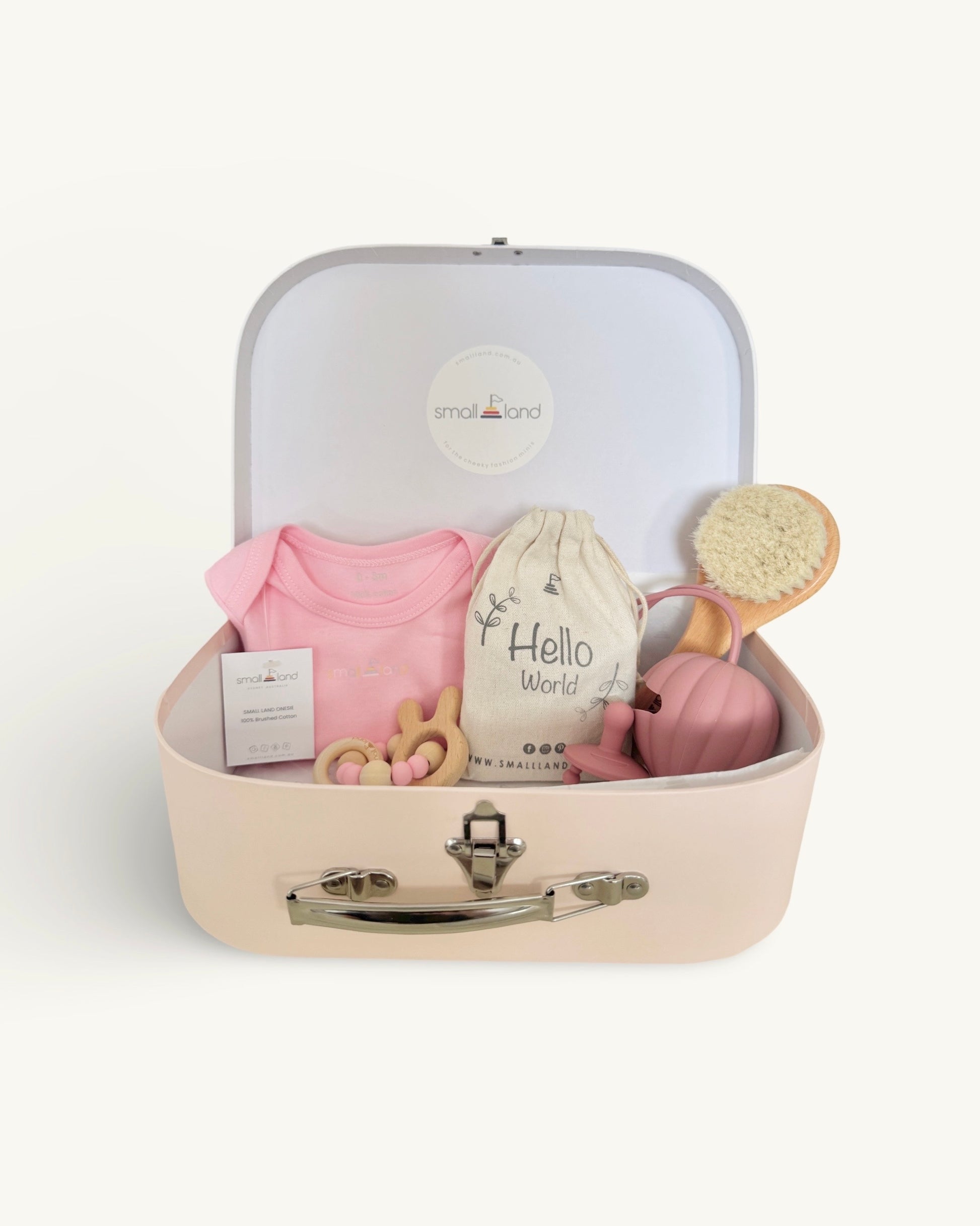 suitcase gift box displayed open with pink onesie, milestone blocks, pink dummy case holder +dummy, newborn hairbrush and bunny teether/rattle toy